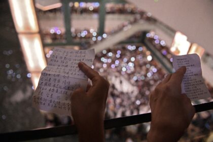 People hold the lyrics to 'Glory to Hong Kong’ at a shopping mall during the city's 2019