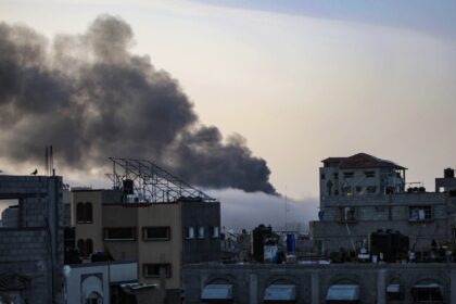 Smoke rises above buildings at sunrise in the aftermath of Israeli bombardment in Rafah in