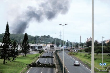 Smoke rises in the distance as roadblocks are seen near the Montravel area of Noumea, capi