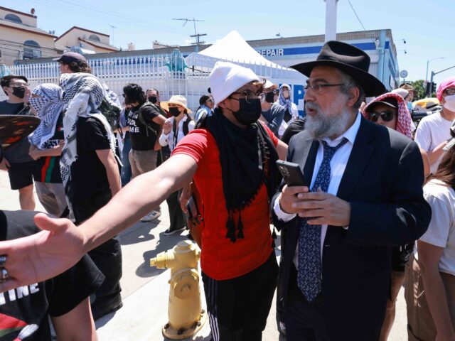 Pro-Palestine protesters (L) prevent access to the Adas Torah Orthodox Jewish synagogue, i