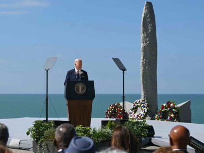 US President Joe Biden delivers a speech in front of the monument on the "Pointe du H
