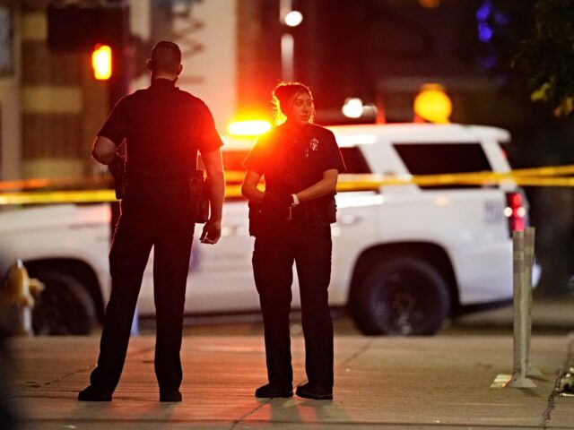 Denver Police Department investigators work the scene of a mass shooting early Tuesday, Ju