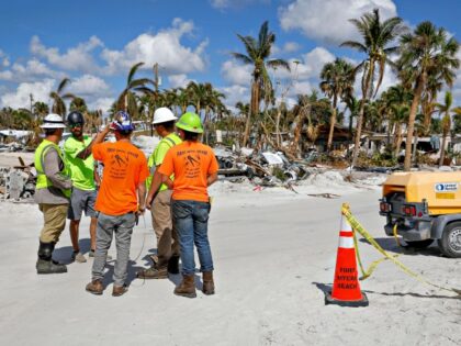 Utility workers speak in Fort Myers Beach, Florida, on November 2, 2022, after Hurricane I