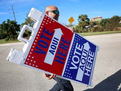 Jene Hinspeter, a Lee County Election official, sets up signs directing voters to the poll