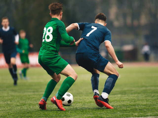 Adult football competition. Soccer football player dribbling a ball and kick a ball during