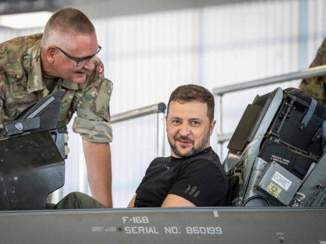 Ukrainian President Volodymyr Zelensky sits in a F-16 fighter jet in the hangar of the Skr