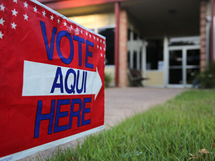 A bilingual sign stands outside a polling center at public library ahead of local election