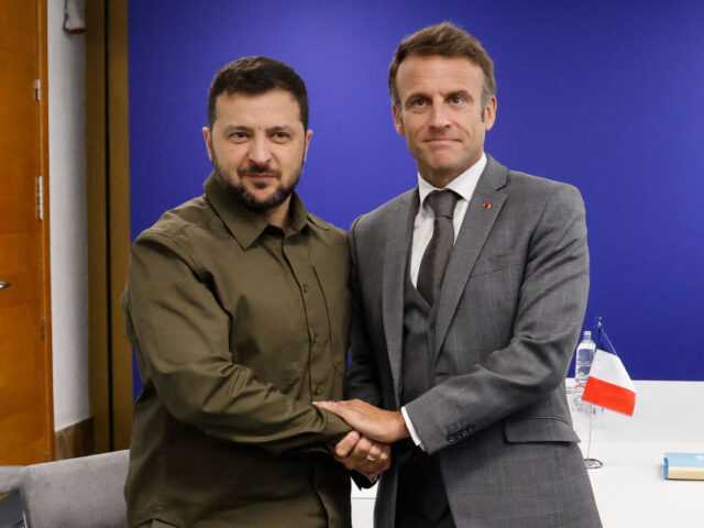 TOPSHOT - Ukraine's President Volodymyr Zelensky (L) shakes hands with French Preside