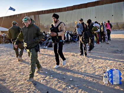 LUKEVILLE, ARIZONA - DECEMBER 08: A U.S. Border Patrol agent leads a group of Indian immig