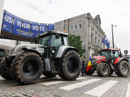 This photograph shows parked tractors in front of a giant poster announcing the upcoming E