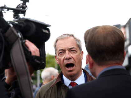 Leader of Reform UK Nigel Farage speaks with a journalist during a visit to Ashfield in no