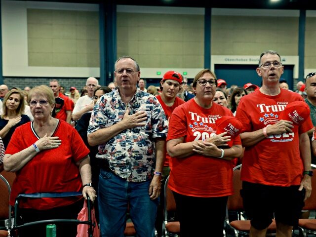 WEST PALM BEACH, FLORIDA - JUNE 14: People recite the Pledge of Allegiance as they wait fo