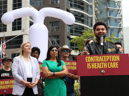 U.S. Rep. Maxwell Frost speaks in front of a 20-foot-plus inflatable IUD at Orlando City H