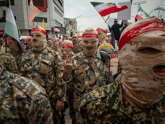 An Islamic Revolutionary Guard Corps (IRGC) military personnel flashes a Victory sign duri