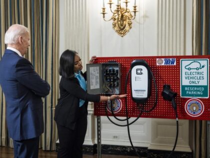 US President Joe Biden, left, views an electric vehicle charger during workforce training