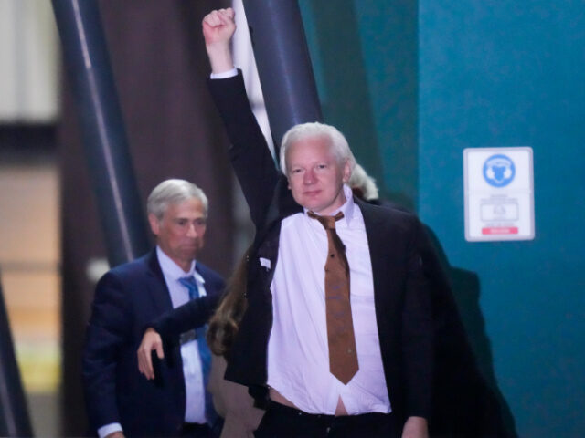 WikiLeaks founder Julian Assange waves after landing at RAAF air base Fairbairn in Canberr
