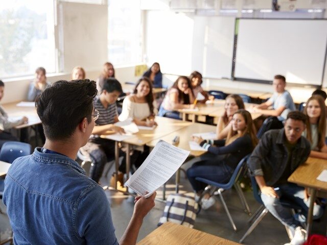 Teacher, students in high school classroom