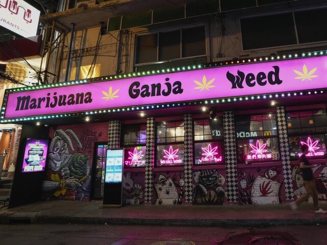 A pedestrian walks past a cannabis shop in Bangkok, Thailand, Wednesday, May 15, 2024. Doz