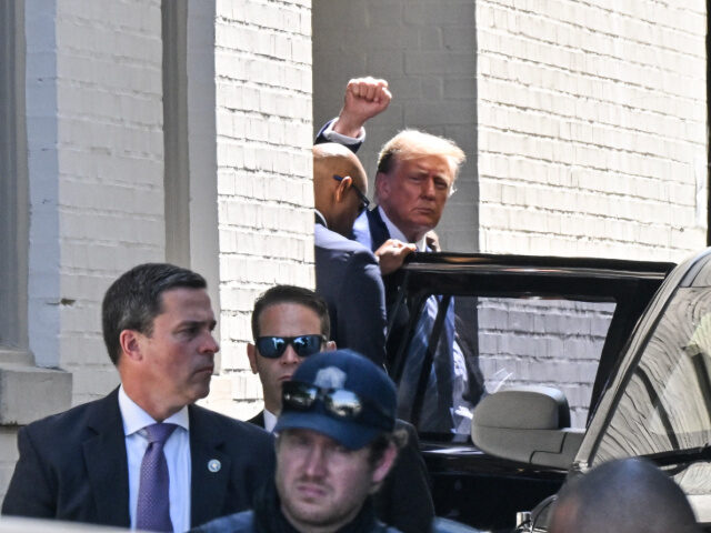 Former President Donald Trump waves as he leaves after a meeting with House GOP members at