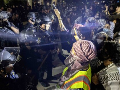 University of California Police officers face pro-Palestinian protesters outside Dodd Hall