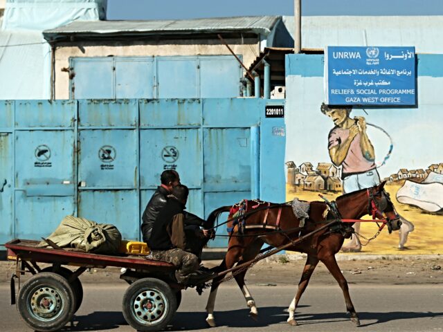 A Palestinian man rides his horse past the UNRWA relief and social programme office in Gaz