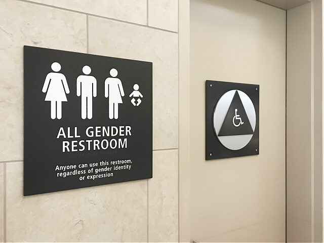 Multi gender bathroom signage in airport - stock photo