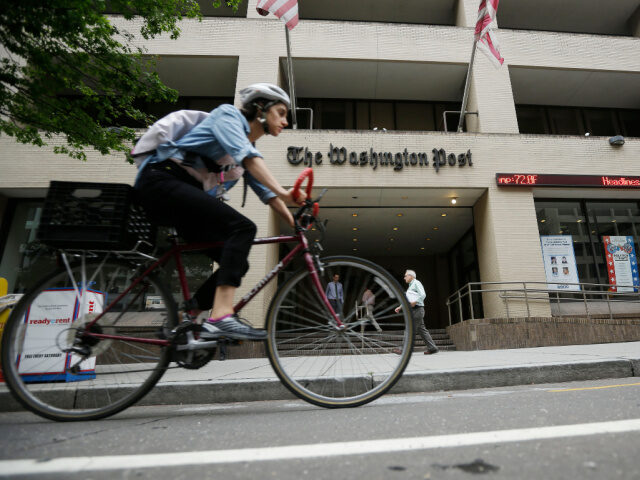 A bicyclist rides past the Washington Post building on Tuesday, Aug. 6, 2013, in Washingto