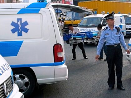 A police officer stand guards as ambulances wait outside the Laoximen Station of Metro Lin
