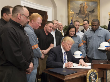 President Donald Trump, surrounded by American steel workers, signs the Section 232 Procla