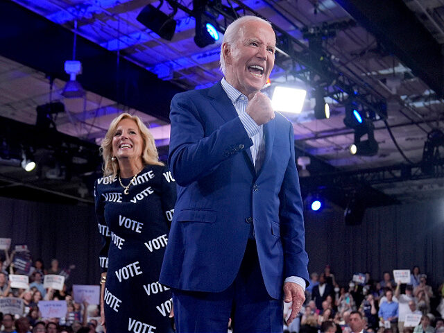 President Joe Biden, right, and first lady Jill Biden walk off stage after speaking at a c