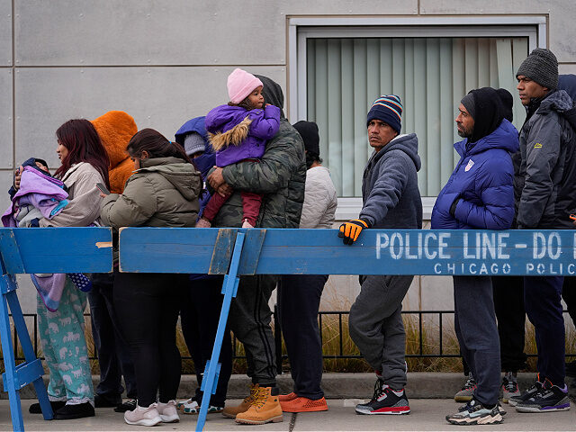 Migrants stand in line to receive food from the nonprofit Chi-Care Thursday, Jan. 11, 2024