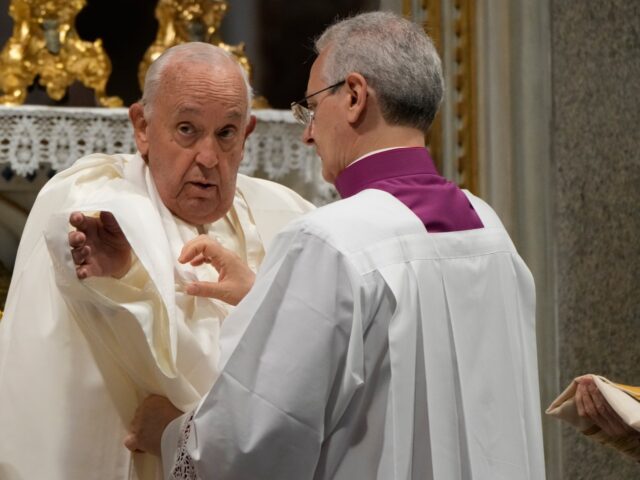 Pope Francis is assisted by his aide Monsignor Diego Ravelli during a mass at the St. John