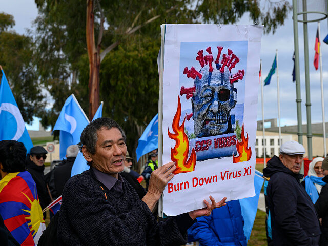CANBERRA, AUSTRALIA - 2024/06/17: A protester seen holding a "Burn Down Virus Xi" placard