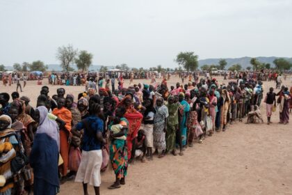 People line up to register for potential food aid delivery at a camp for internally displa