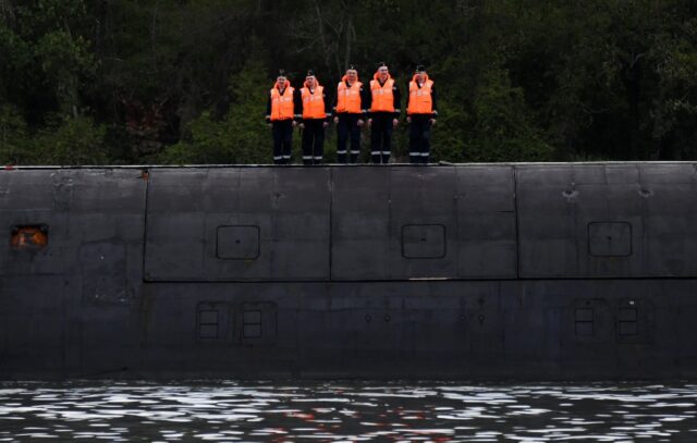 Russian Marines stand guard on top of the Russian nuclear-powered submarine Kazan, part of