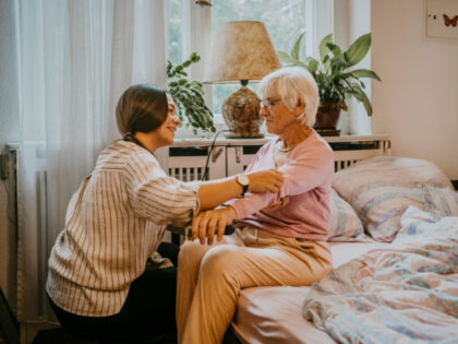 Female healthcare worker helping senior woman