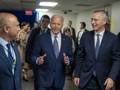 President Joe Biden talks with NATO Secretary General Jens Stoltenberg as he walks to a me