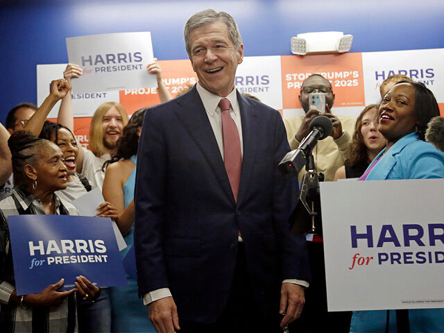 N.C. Governor Roy Cooper smiles as he steps up to speak, speaks at a press conference, Thu