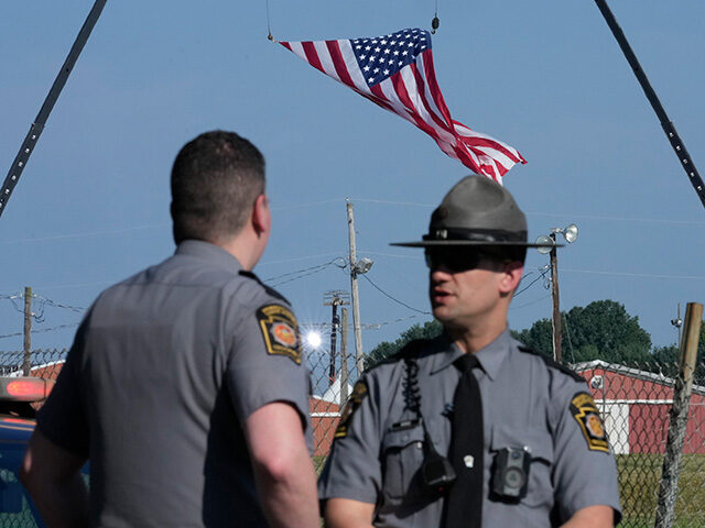 Police officers stand at a road leading to the site of the Trump rally, where access is cl