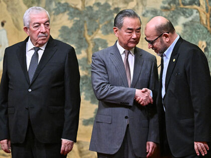 China's Foreign Minister Wang Yi, center, hosts an event for Mahmoud al-Aloul, left, vice