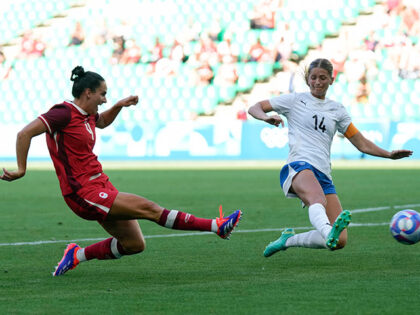 Canada's Evelyne Viens, left, scores her side's 2nd goal during the women's Group A soccer