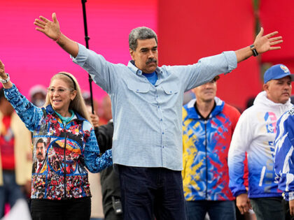 President Nicolas Maduro opens his arms alongside first lady Cilia Flores during his closi