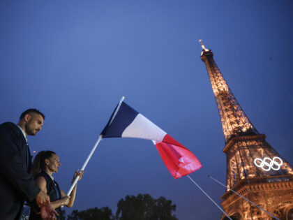 Florent Manaudou, left, and Melina Robert-Michon, right, flag bearer of France sail in a b