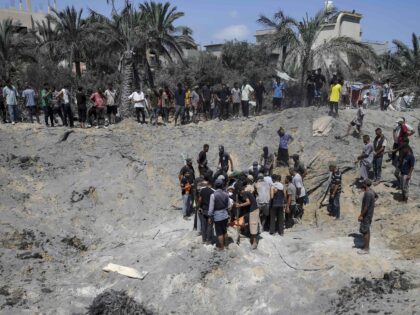 Palestinians search for bodies and survivors in a site hit by an Israeli bombardment on Kh