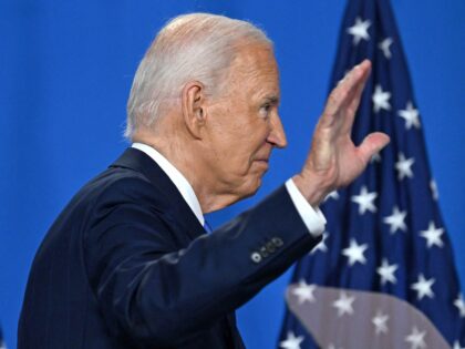 TOPSHOT - US President Joe Biden waves as he leaves after speaking during a press conferen