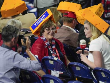A photographer takes a picture of a delegate with a cheesehead during the Republican Natio