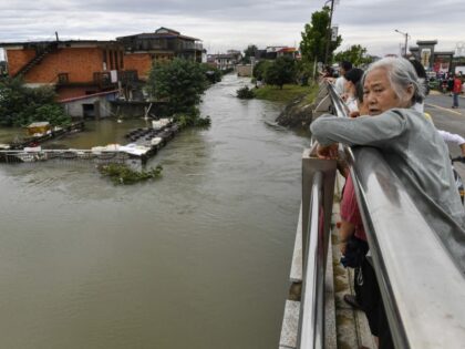 The photo taken on July 2, 2024, shows local residents looking at submerged buildings on a