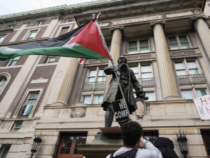 FILE - A student protester parades a Palestinian flag outside the entrance to Hamilton Hal