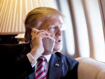 President Donald Trump talks on the phone aboard Air Force One during a flight to Philadel
