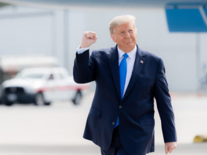 President Donald J. Trump gestures with a fist pump as he walks across the tarmac upon his